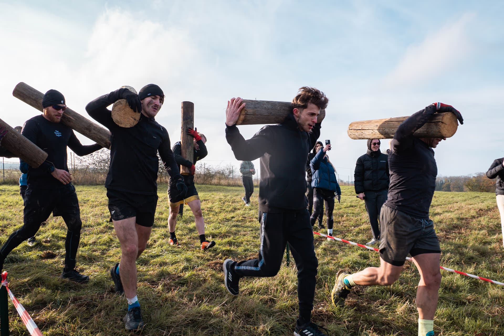 Coureurs Overbound franchissant un obstacle avec des troncs d'arbres
