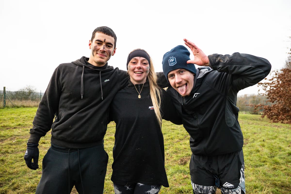 Un groupe d'amis bénévoles d'Overbound célébrant après une course ensemble, heureux et fiers
